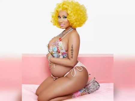Nicki Minaj holding her flaunting the baby bump.